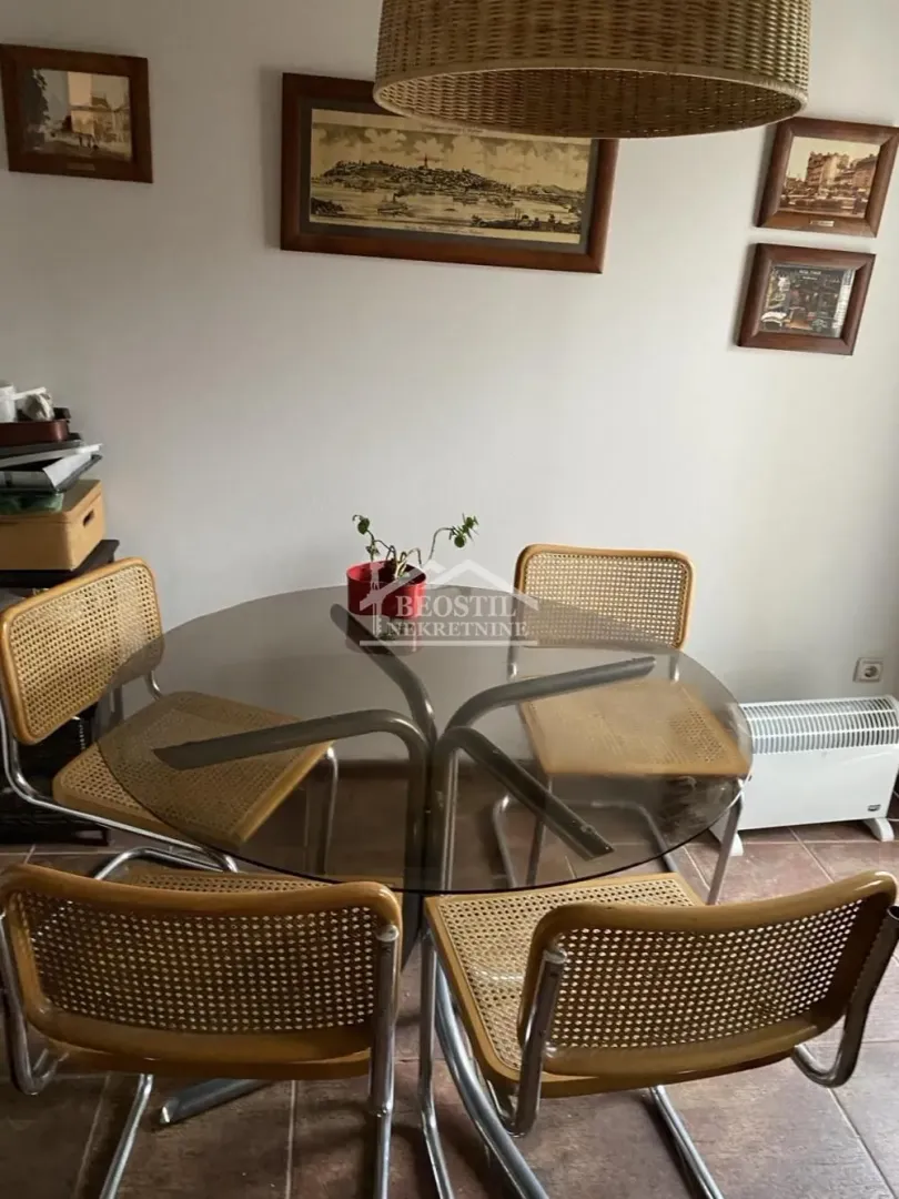Trpezarijski sto sa stolicama u svetloj prostoriji.