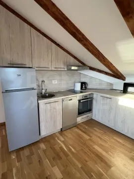 Attic kitchen with wooden beams and built-in appliances. - image 8