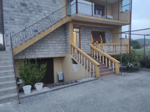 Exterior of a house with a stone facade, concrete stairs, and a balcony. - image 10
