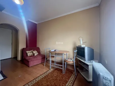 Small living room with a sofa, dining table, and television. - image 3