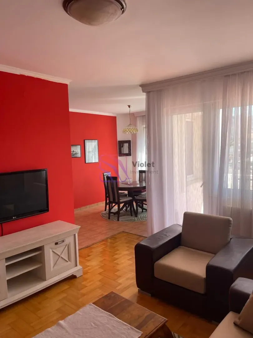 Living room with sofa set and dining area in the background.