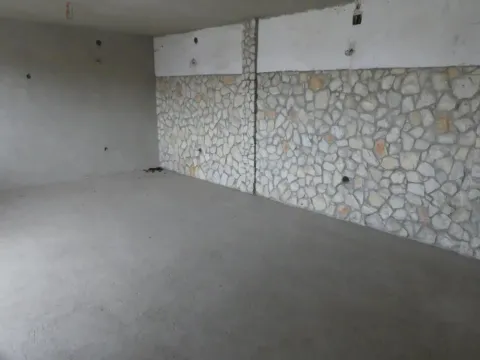 Unfinished room with a stone-clad wall and rough flooring. - image 5