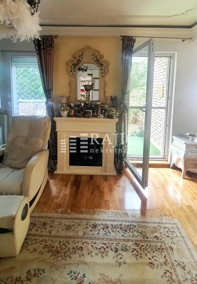 Living room with a fireplace, mirror, and access to the terrace.