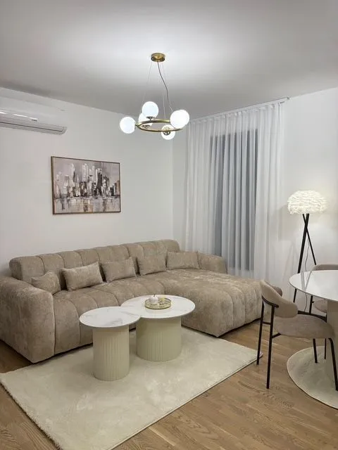 Dnevna soba sa garniturom, stočićima i trpezarijskim stolom.