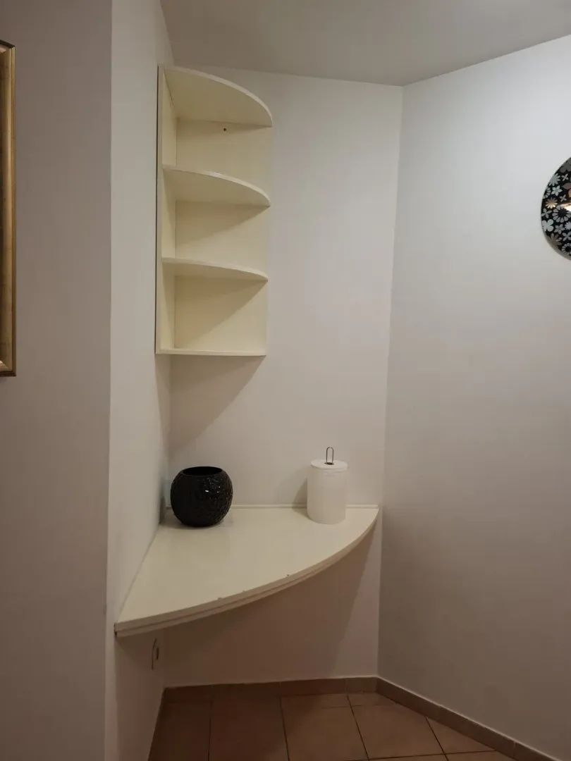 Ugaona polica sa dekorativnim detaljima u unutrašnjosti.