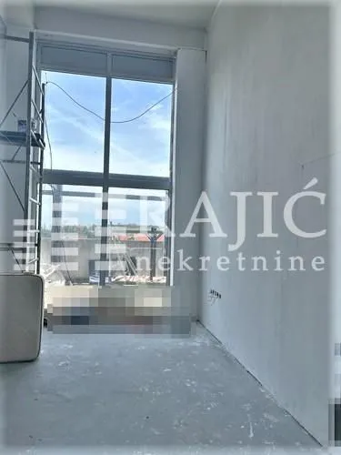 Empty room under construction with a large window and scaffolding.