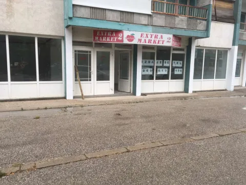 Exterior view of a commercial space with display windows and a market sign. - image 5