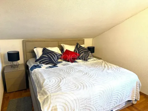 Furnished bedroom with a double bed under a sloped ceiling. - image 7