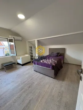Attic bedroom with a bed, armchair, and wardrobe. - image 13