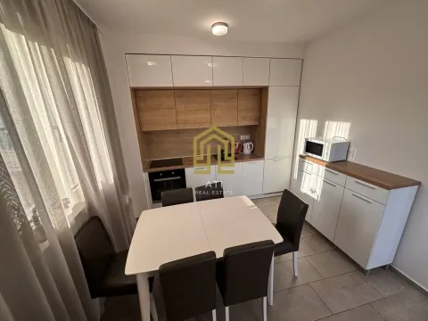 Kitchen with dining area equipped with white units and wooden details. - image 8