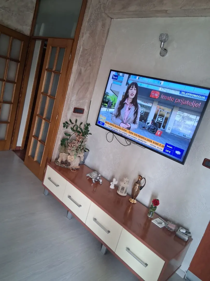 Dnevni boravak sa TV komodom i televizorom.