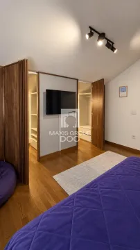 Spavaća soba sa krevetom, televizorom na zidu i ugradnim ormanom. - image 9