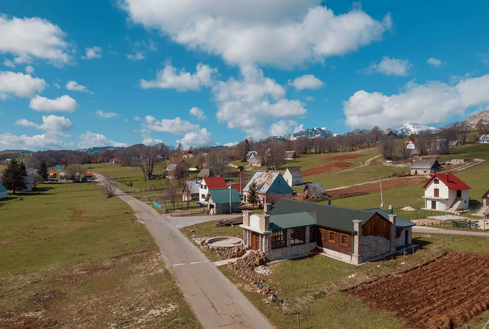 Aerial view of a rural estate with houses and surrounding nature.
