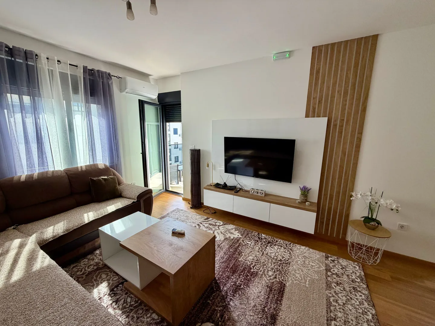 Living room with a sofa, TV, and access to the terrace.