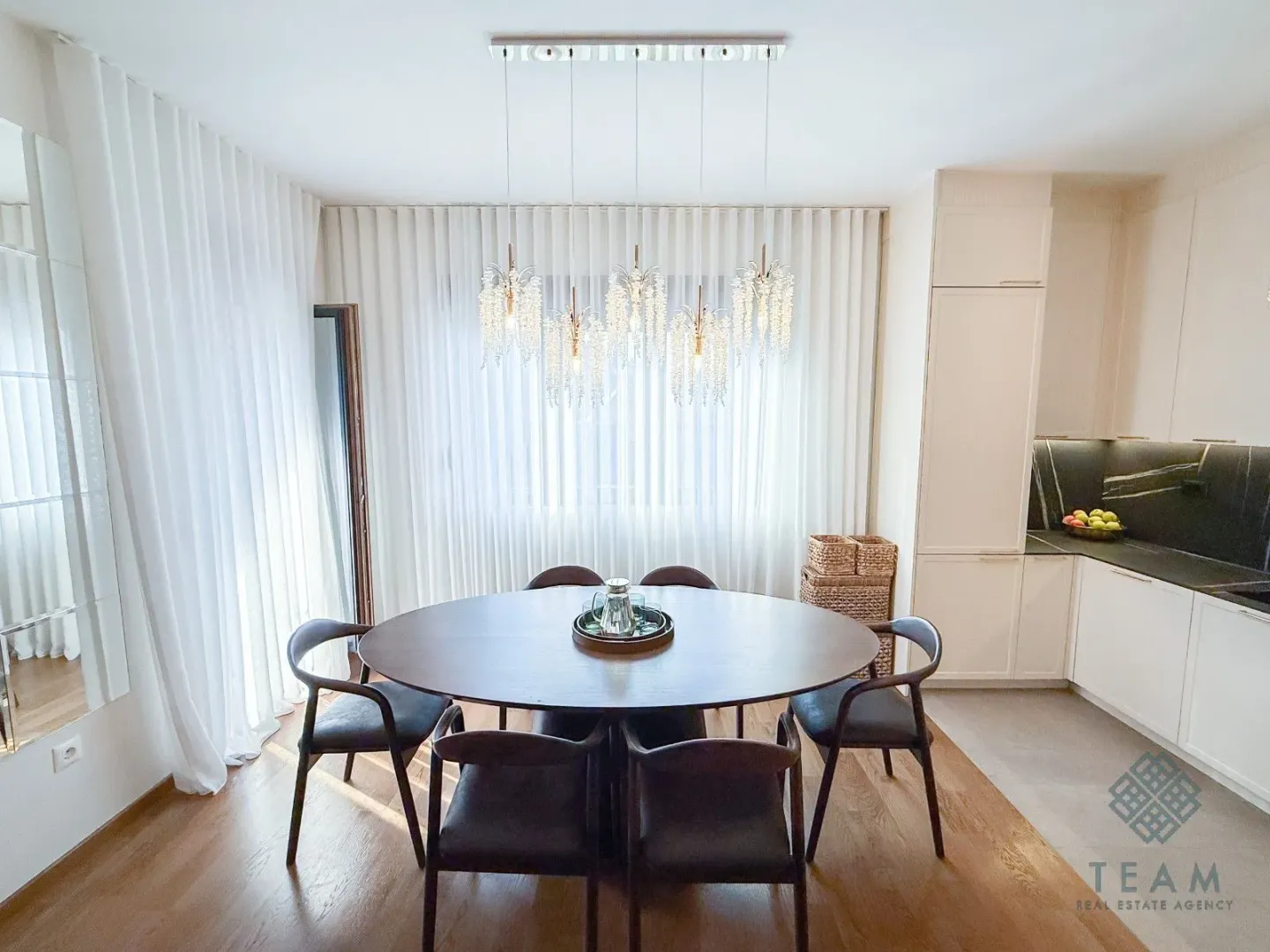 Dining area with a round table and chairs next to the kitchen.