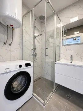 Moderno opremljeno kupatilo sa tuš kabinom, umivaonikom i veš mašinom. - image 7