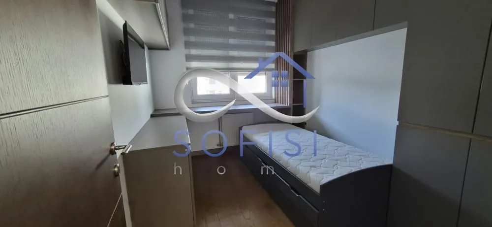 Small bedroom with a single bed and built-in closets.