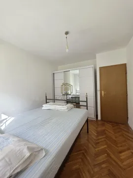 Spavaća soba sa krevetom, bijelim garderoberom i drvenim parketom. - image 8