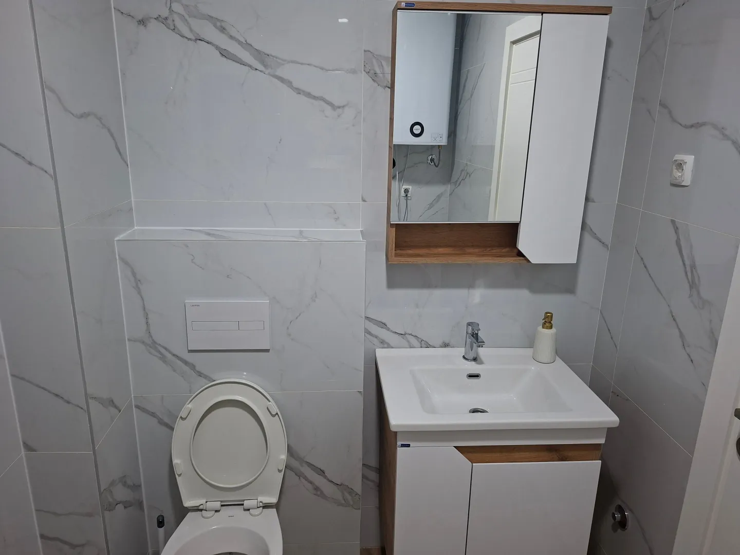 Modern bathroom with white marble-pattern ceramic tiles.