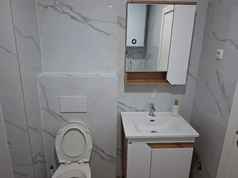 Modern bathroom with white marble-pattern ceramic tiles. - image 13