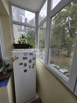 Zastakljeni balkon sa frižiderom i pogledom na zelenilo. - image 9