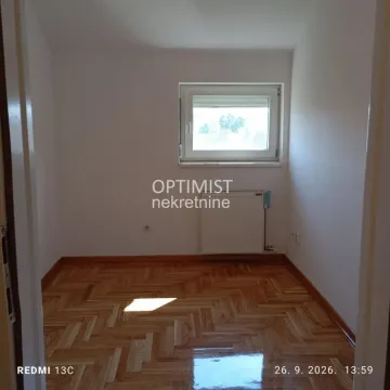 Empty room with parquet flooring and a single window. - image 13