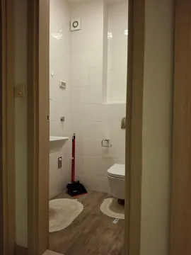 View through the doorway into a tidy bathroom with white tiles. - image 2