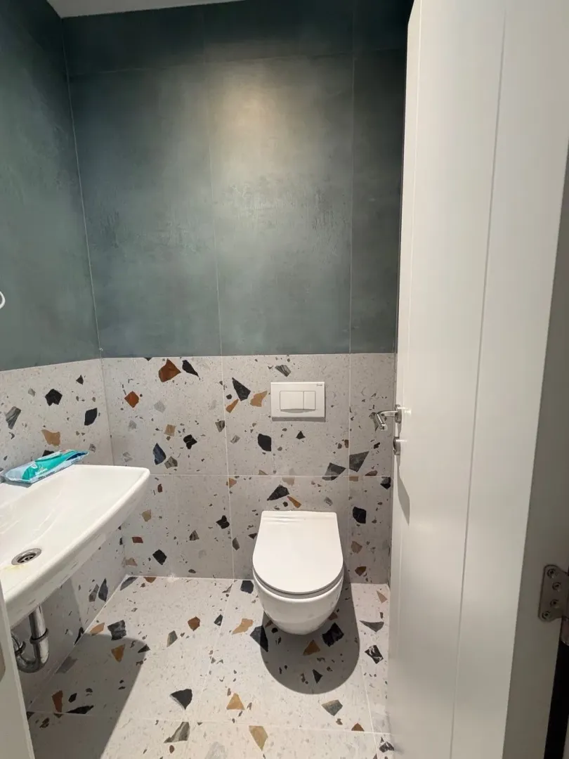 Manje kupatilo sa modernim pločicama i sanitarijama.