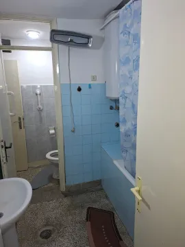 Smaller bathroom with a bathtub, blue tiles, and sanitary fixtures. - image 5