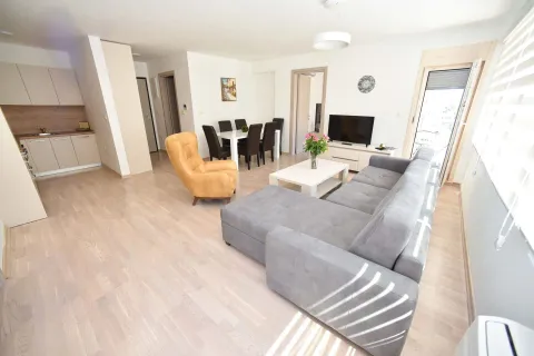 Spacious living room with a sofa set, dining area, and kitchen in the background. - image 16