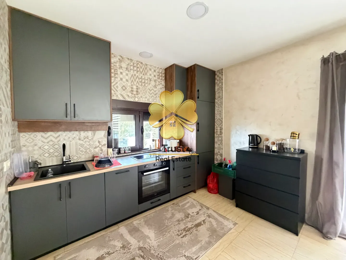 Modern kitchen with dark cabinetry and an integrated dining area.