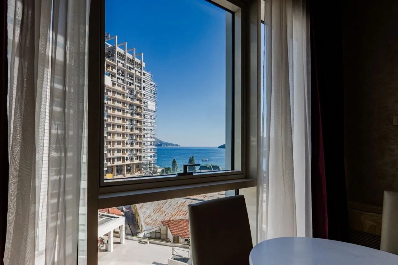 Sea and city view through the window from an interior with curtains.