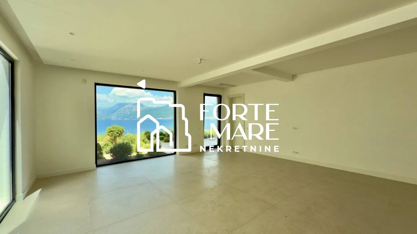 Empty bright room with large windows and a sea view.