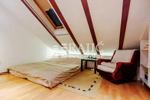 Attic furnished as a bedroom with a bed and a roof window. - image 8