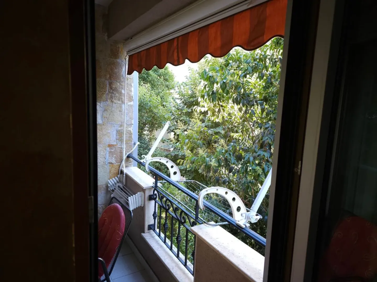 Pogled na terasu i zeleno drveće iz unutrašnjosti stana.