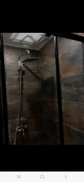 Tuš kabina sa tamnim keramičkim pločicama i modernom slavinom. - image 8