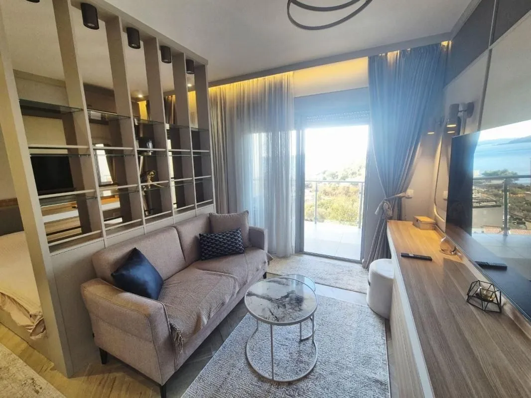 Living room with sofa, coffee table and access to a terrace with sea view.