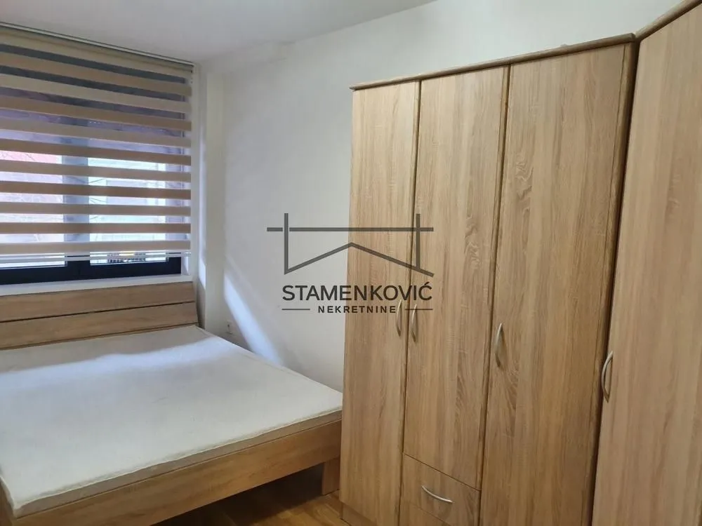 Bedroom with a double bed and a wooden wardrobe.