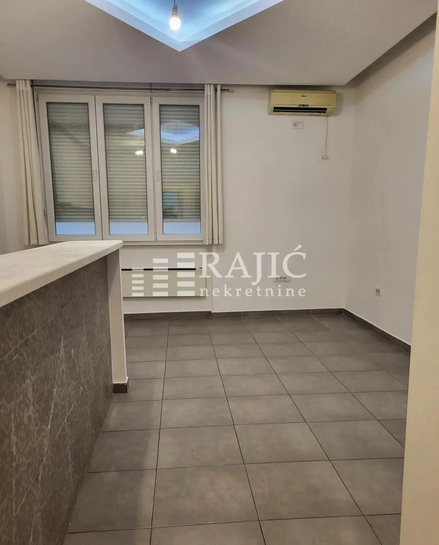 Empty room with tiled flooring and a window.