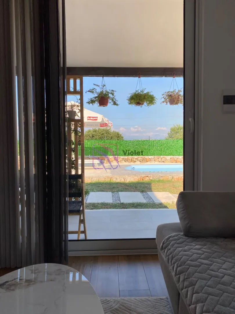 View from the living room to the courtyard with a swimming pool and terrace.