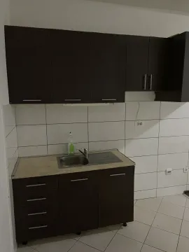 Mala kuhinja sa tamnim elementima i bijelim pločicama. - image 2