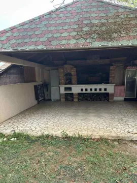 Covered backyard area with a built-in barbecue and tiled floor. - image 8