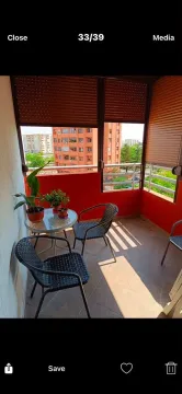 Natkriveni balkon sa garniturom za sedenje i pogledom na gradsko okruženje. - image 2