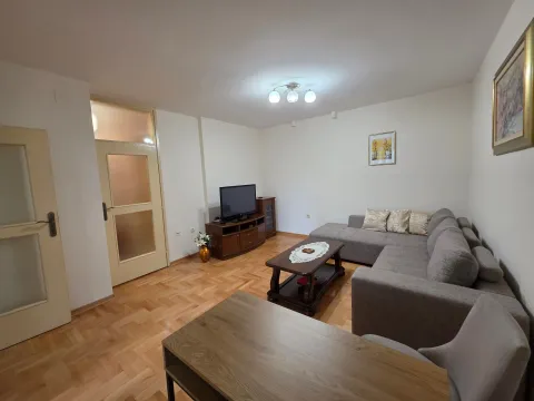 Living room with a sectional sofa, coffee table and television. - image 3