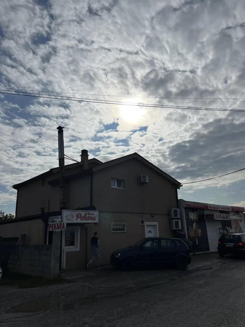 Eksterijer dvospratne zgrade sa poslovnim prostorima pod oblačnim nebom.