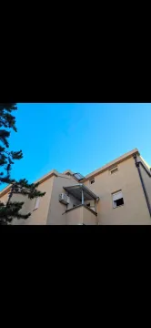 Pogled na spoljašnjost zgrade sa balkonom i prozorima. - image 10