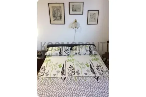 Spavaća soba sa bračnim krevetom i slikama na zidu. - image 6