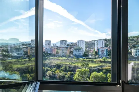 View through the window of the city and surrounding landscape with buildings and greenery. - image 9
