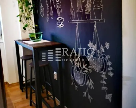 Small dining area with a bar table and a decorative wall. - image 4