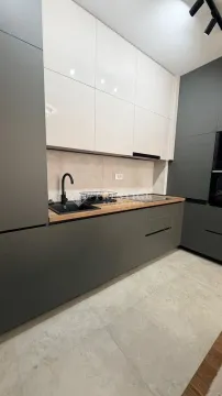 Modern kitchen with dark grey and white cabinets. - image 5